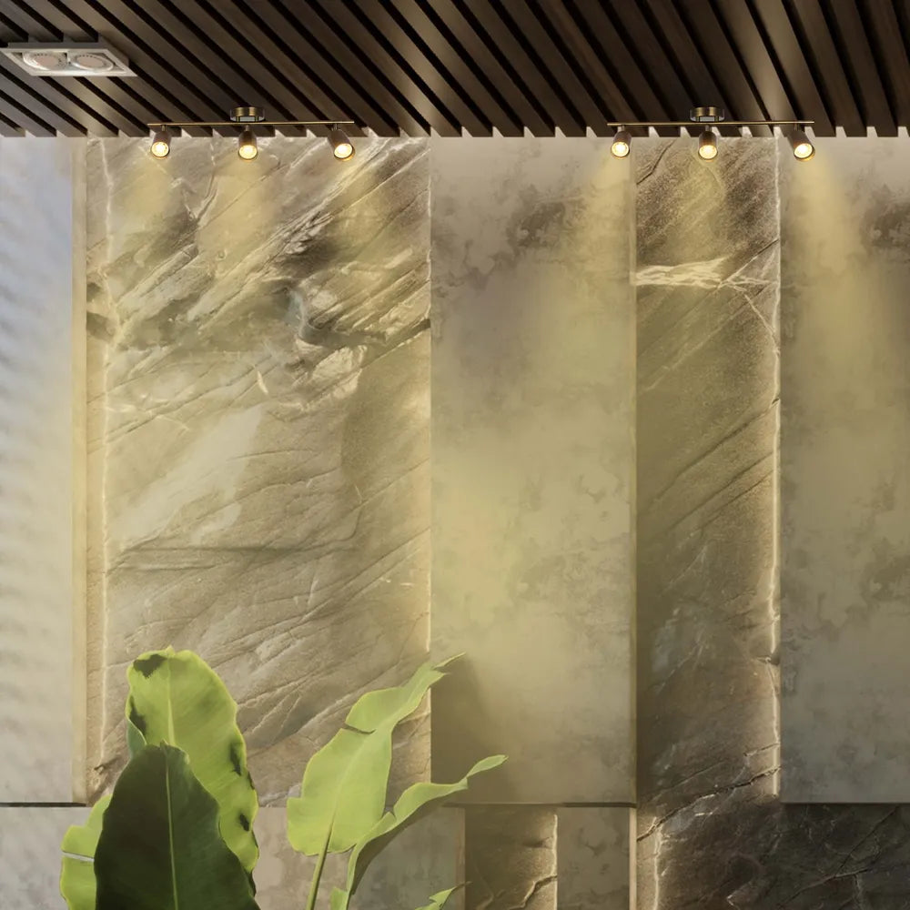 Barra de focos de latón antiguo GU10 que ilumina una sala de estar moderna con decoración elegante, mejorando el ambiente y la funcionalidad.172-030623