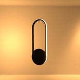 Aplique de pared LED negro de forma elíptica, ideal para salas modernas y espacios con un estilo contemporáneo.