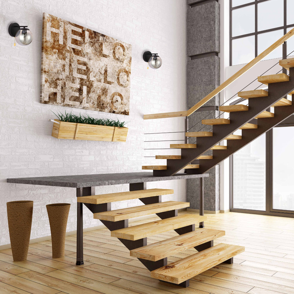 Luz de pared moderna con cuerpo de metal cromo y vidrio ahumado, perfecta para decoraciones contemporáneas en salas o pasillos.