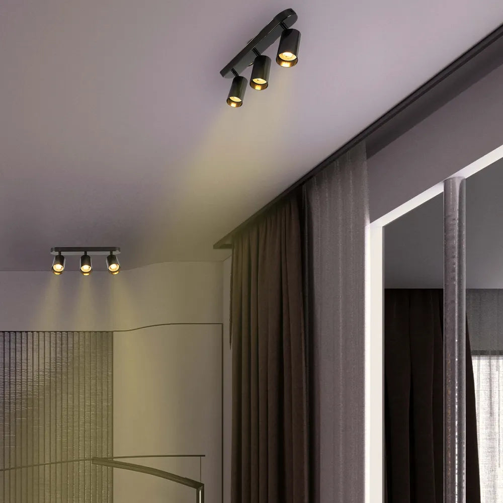 Astra Pearl Grey Cilindro GU10 Foco iluminando una sala de estar moderna con decoración minimalista, mejorando el ambiente elegante.172-030393