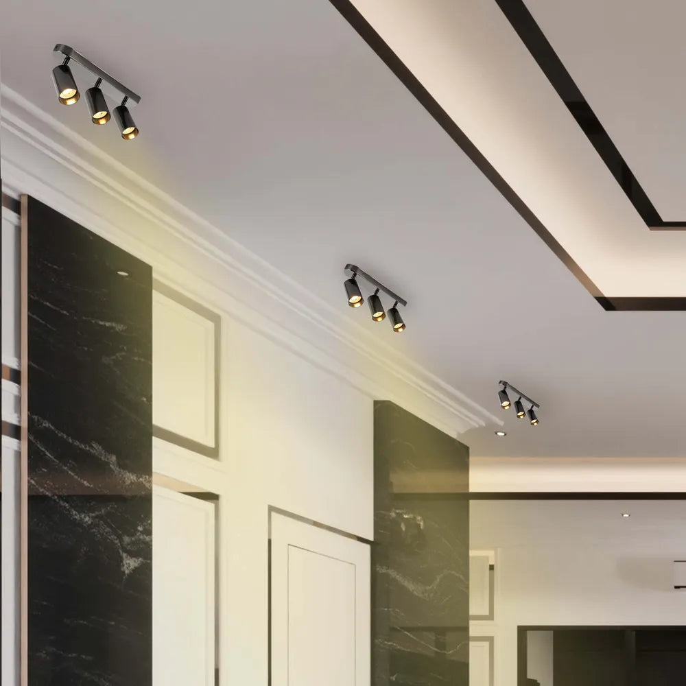 Foco cilíndrico moderno gris GU10 iluminando una sala de estar elegante, mejorando una decoración minimalista con iluminación suave y ambiental.172-030393