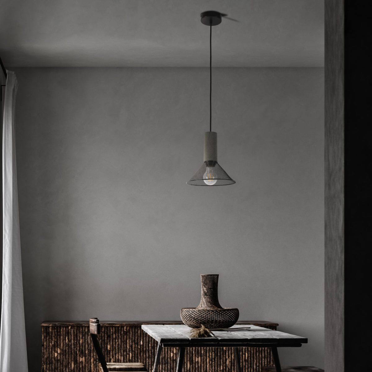 Conjunto de lámparas colgantes de concreto texturizado en una cocina moderna, añadiendo un toque industrial y elegante al espacio.