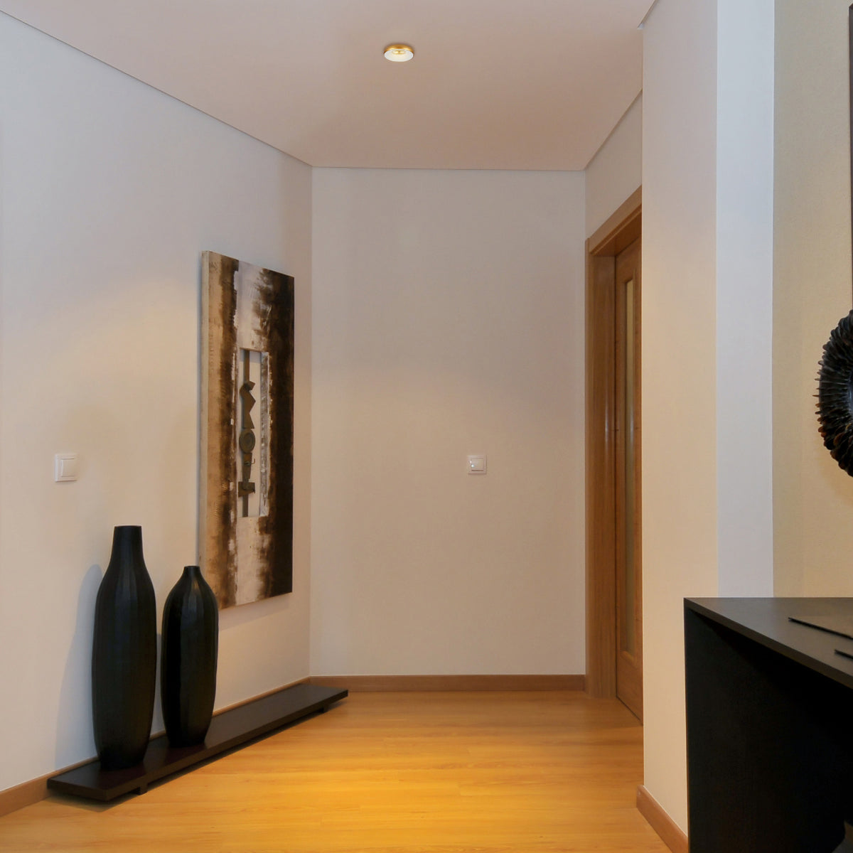 Foco empotrado de aluminio con acento colorido, ideal para salones modernos y contemporáneos, resaltando la decoración del espacio.
