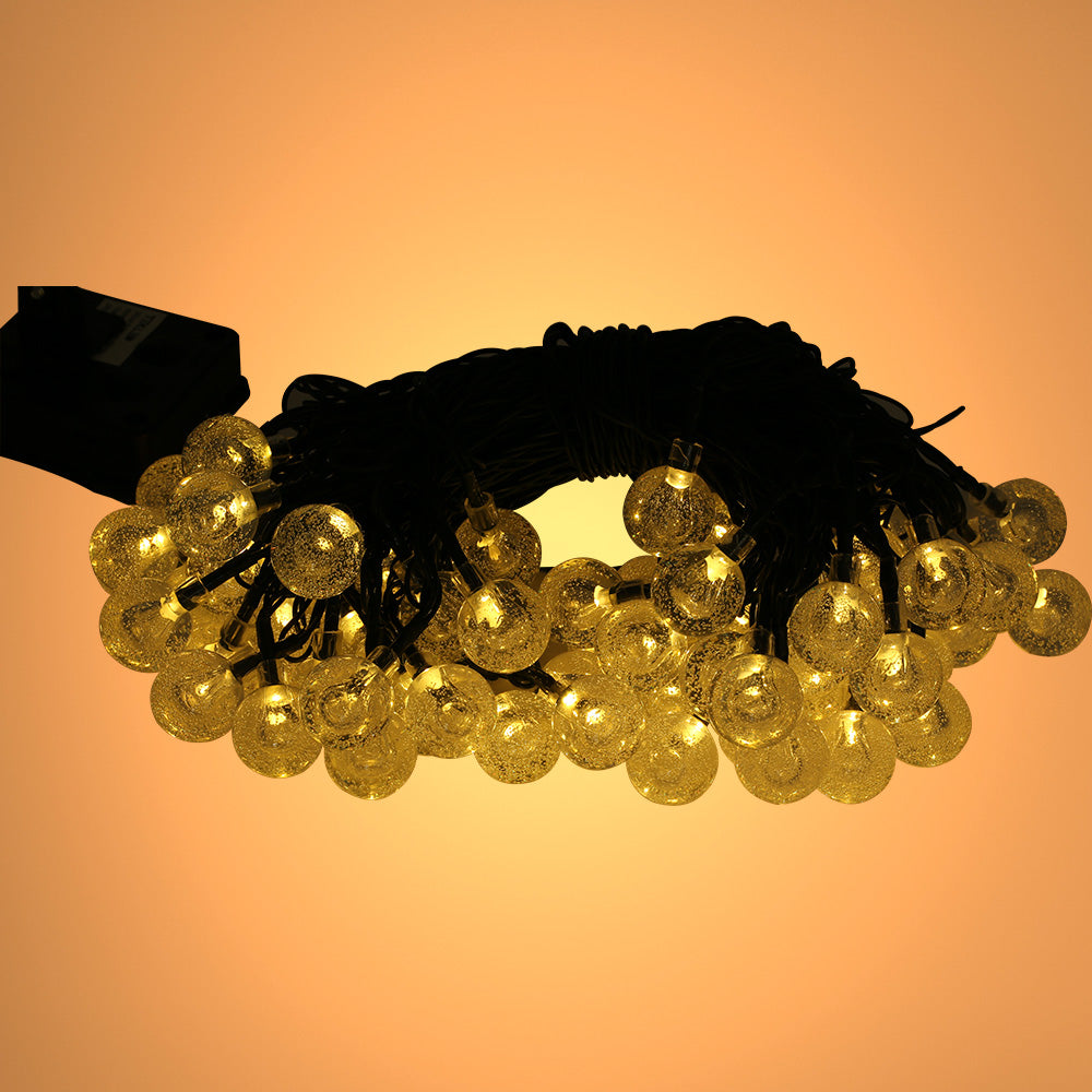Imagen principal de luces de cadena solares con 60 LEDs, perfectas para exteriores y decoraciones festivas en jardines rústicos.