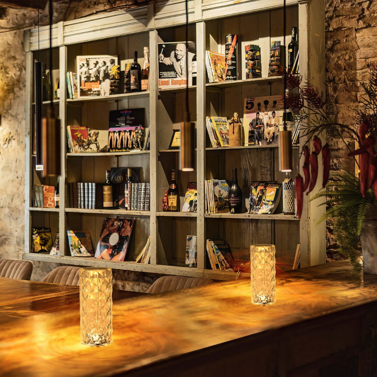 Lámpara cilíndrica recargable de cristal iluminando un elegante espacio exterior, ideal para decoraciones modernas y acogedoras.