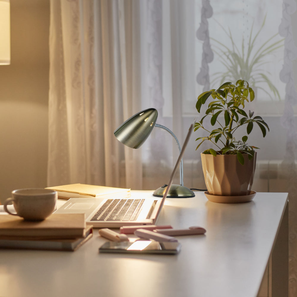Lámpara de escritorio metálica con cuello flexible, perfecta para oficinas modernas, ofreciendo iluminación ajustable y estilo contemporáneo.