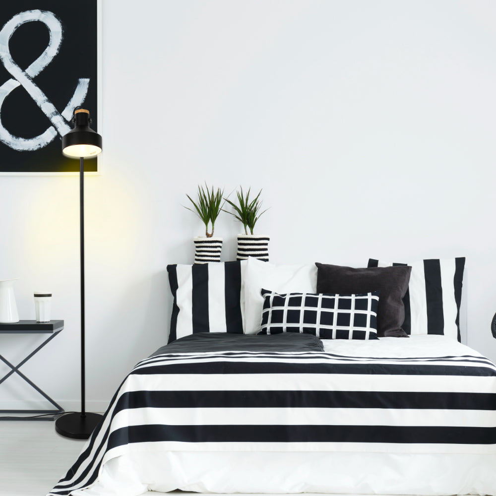 Lámpara de pie minimalista ajustable con acentos de madera, ideal para salones modernos y espacios de trabajo elegantes.