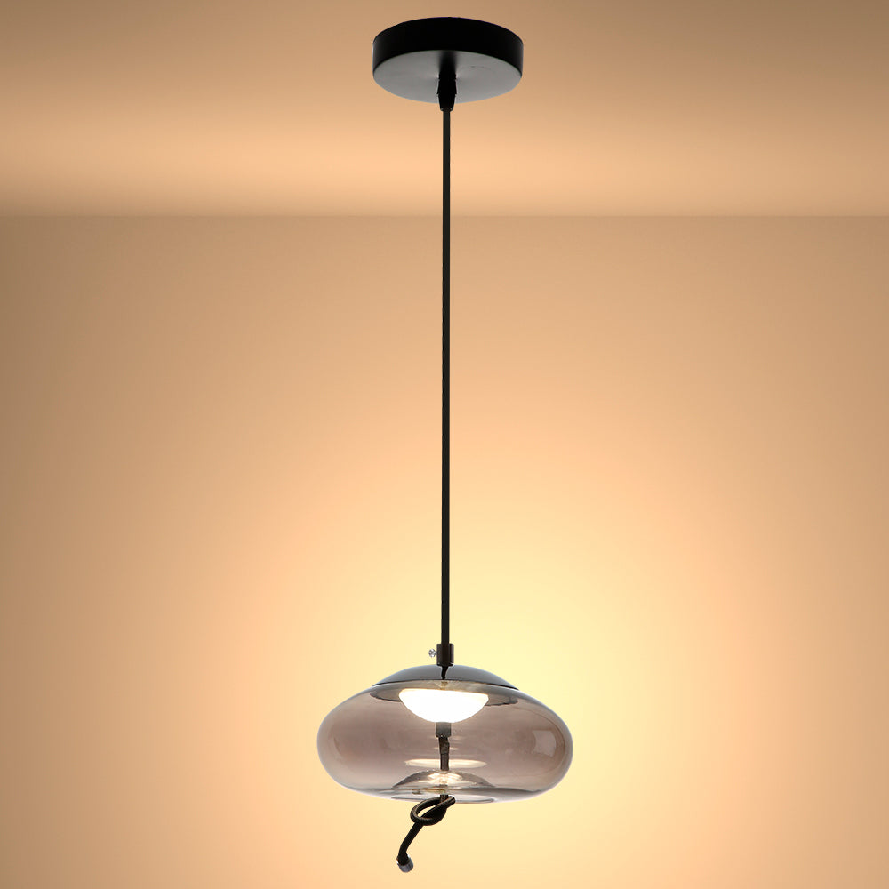 Luz colgante de vidrio ahumado en forma de esfera, perfecta para comedores con decoración moderna y elegante.
