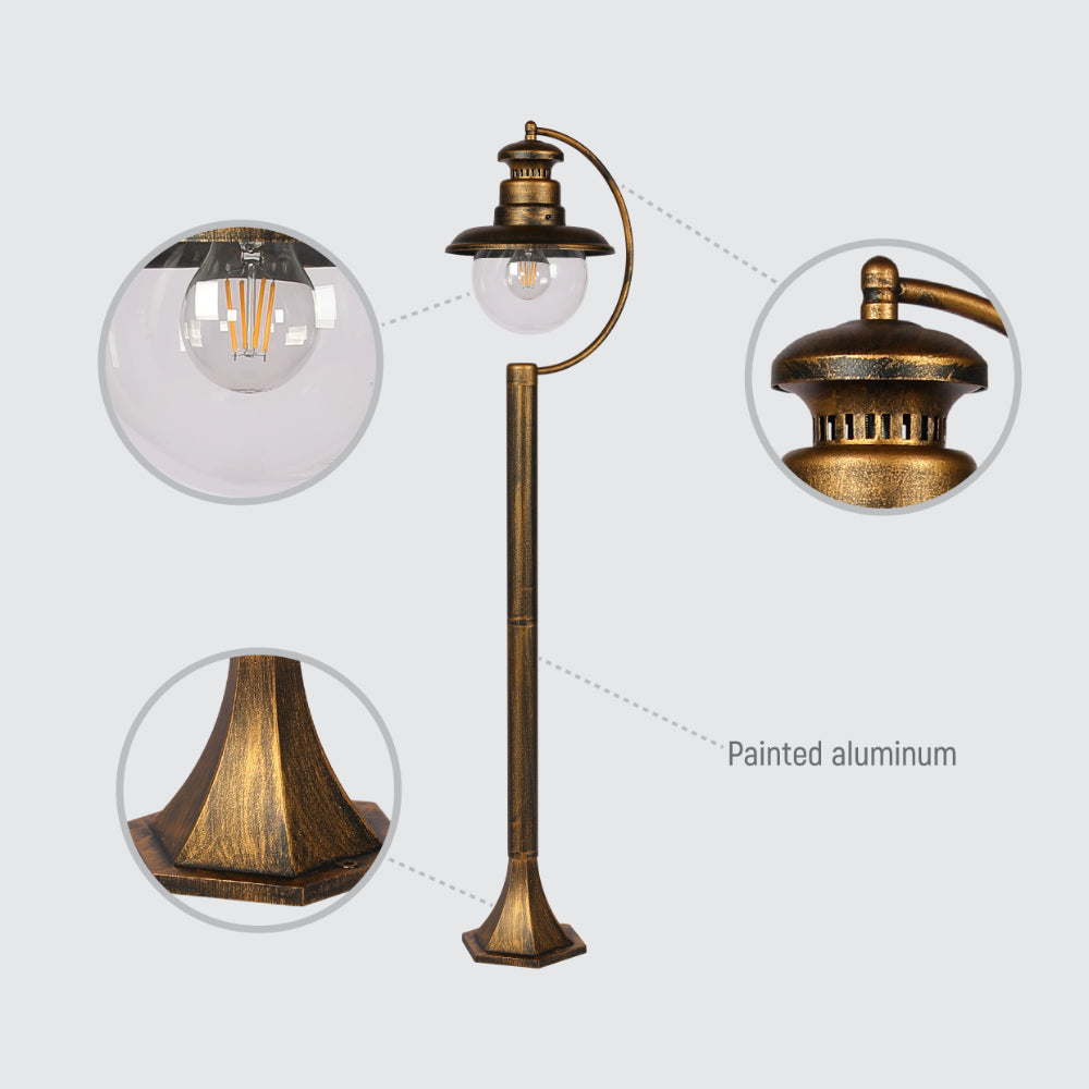 Luz exterior tipo bolardo negra con detalles dorados, perfecta para iluminar caminos en jardines con estilo moderno.