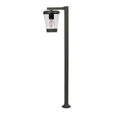 Luz de bollardo de exterior, ideal para iluminar caminos en jardines modernos, con estructura de aluminio oscuro y diseño elegante.