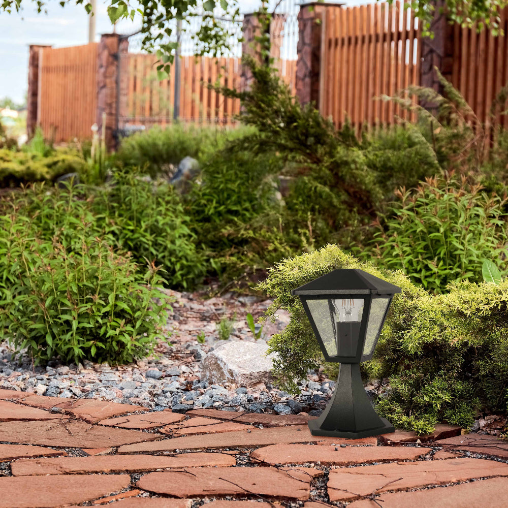 Lámpara de pedestal exterior en negro, ideal para jardines de estilo contemporáneo, proporcionando luz cálida y acogedora.