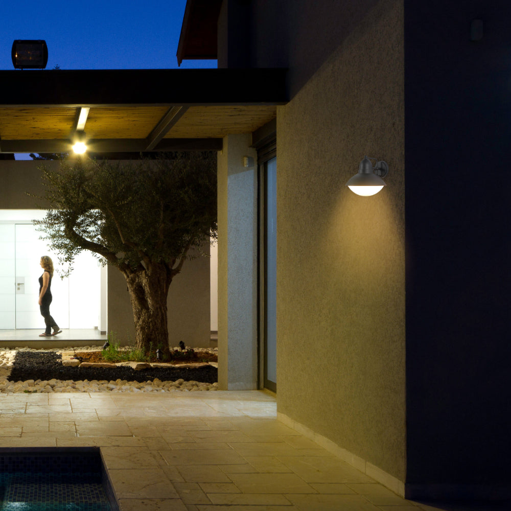 Luz de pared tipo linterna exterior, de diseño industrial elegante, ideal para patios o entradas con decoración moderna.