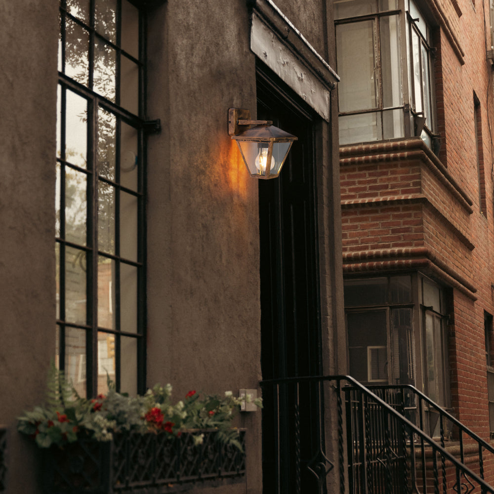 Luz de pared exterior en forma de farol, perfecta para patios con estilo contemporáneo y ambiente acogedor.