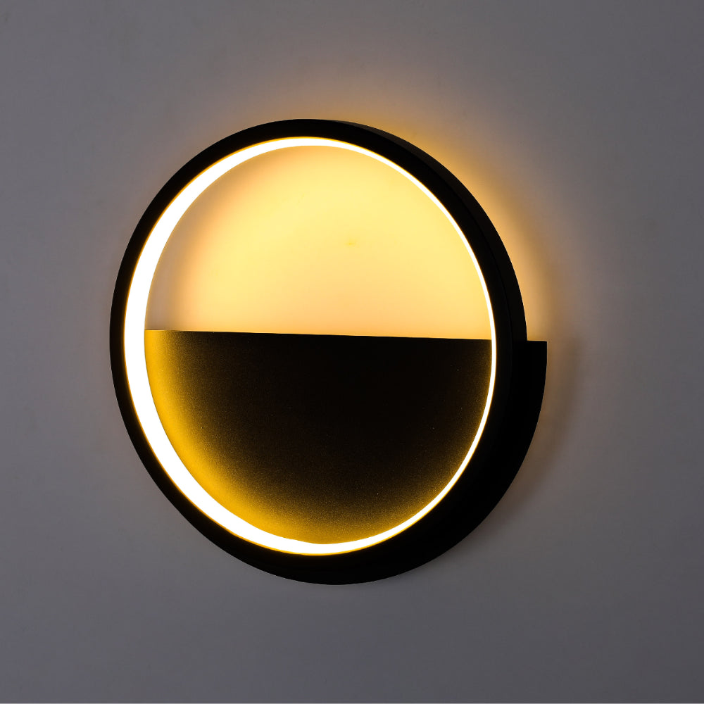 Luz de pared LED redonda negra, ideal para cuartos contemporáneos, proporcionando iluminación cálida y uniforme en espacios modernos.