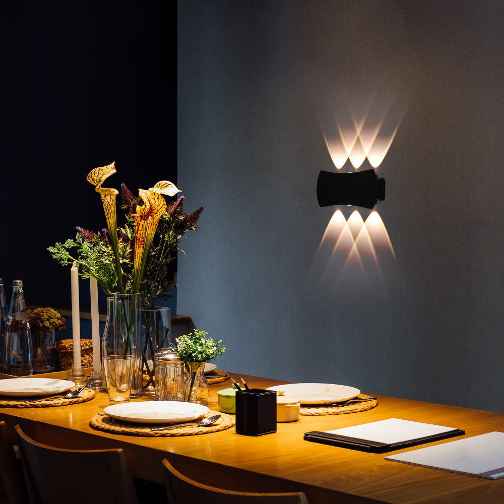 Luz de pared LED moderna exterior negra, ideal para patios contemporáneos, emitiendo luz hacia arriba y abajo.