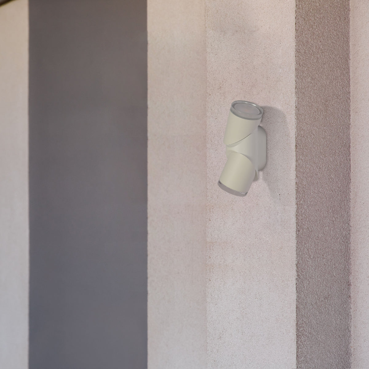 Luz de pared LED exterior de cilindros rotativos, ideal para patios modernos, ofreciendo iluminación amplia y funcional.