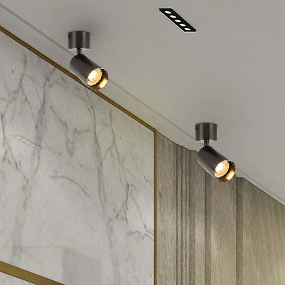 Elegante foco empotrado de superficie GU10 giratorio que ilumina una sala de estar moderna con una decoración elegante y acentos vibrantes.172-030282