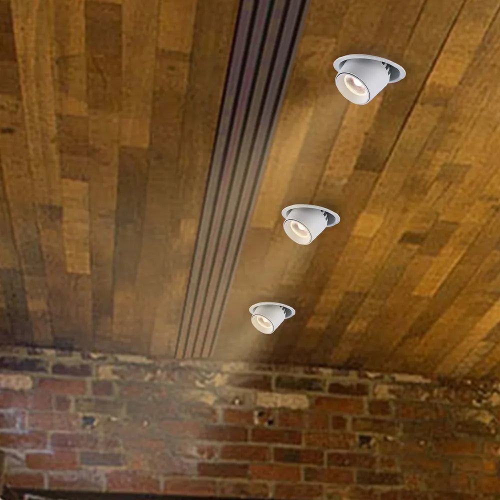 Luz empotrada LED elegante con cardán ajustable, iluminando una sala de estar moderna con decoración contemporánea y ambiente cálido.143-03409