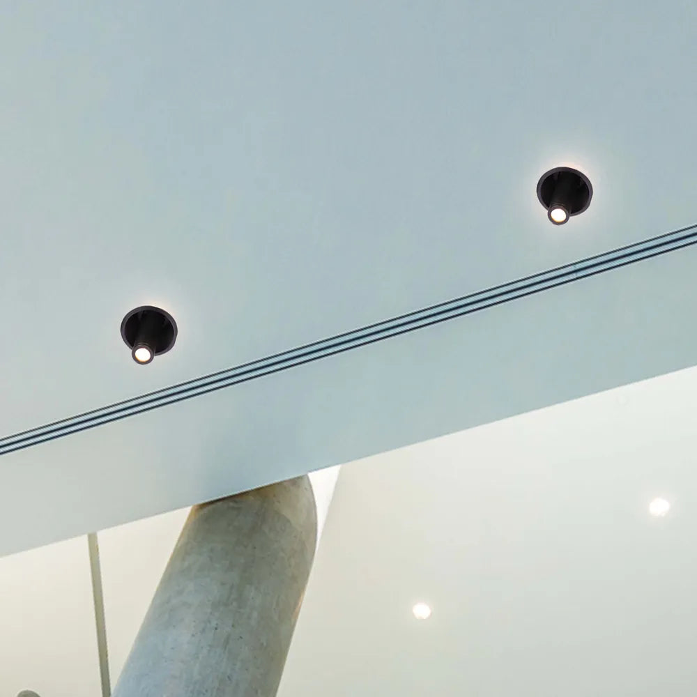 Elegante downlight LED en sala de estar moderna, mejorando la decoración minimalista con gimbal ajustable para iluminación enfocada y ambiente.143-03416