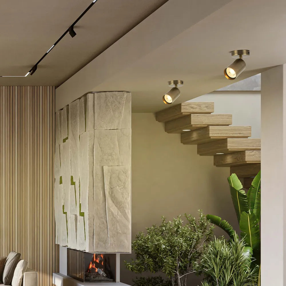 Barra de focos GU10 de latón antiguo presentada en una sala de estar elegante, mejorando el decorado moderno con una iluminación cálida y elegante.172-030621