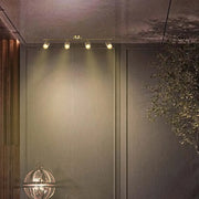 Barra de foco GU10 en latón antiguo iluminando una sala de estar elegante con decoración moderna, realzando la atmósfera y mostrando la elegancia del diseño.