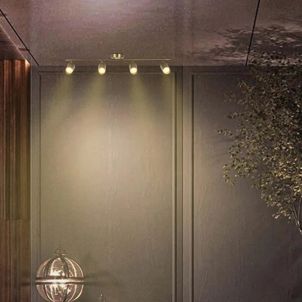 Barra de foco GU10 en latón antiguo iluminando una sala de estar elegante con decoración moderna, realzando la atmósfera y mostrando la elegancia del diseño.