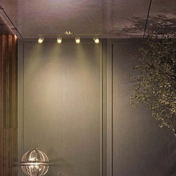 Barra de foco GU10 en latón antiguo iluminando una sala de estar elegante con decoración moderna, realzando la atmósfera y mostrando la elegancia del diseño.