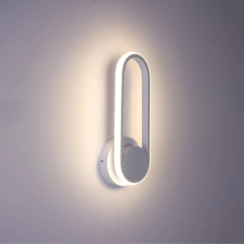 Aplique de pared LED en forma elíptica, ideal para espacios modernos con decoración minimalista y luz blanca fría.