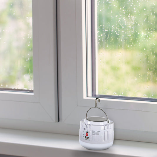 Foto de una lámpara LED de emergencia recargable, perfecta para camping o uso en exteriores, con diseño funcional y moderno.