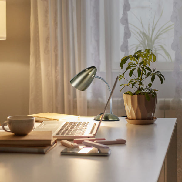 Lámpara de escritorio metálica con cuello flexible, perfecta para oficinas modernas, ofreciendo iluminación ajustable y estilo contemporáneo.
