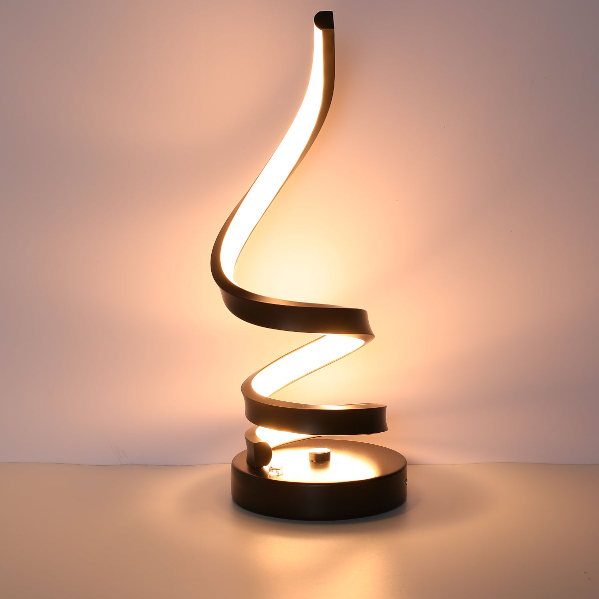 Lámpara de mesa LED en espiral contemporánea con acabado negro, ideal para oficinas o salas modernas, proporcionando iluminación ajustable.