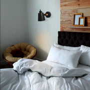 Lámpara de pared ajustable con diseño cónico moderno, perfecta para espacios minimalistas y salones contemporáneos.