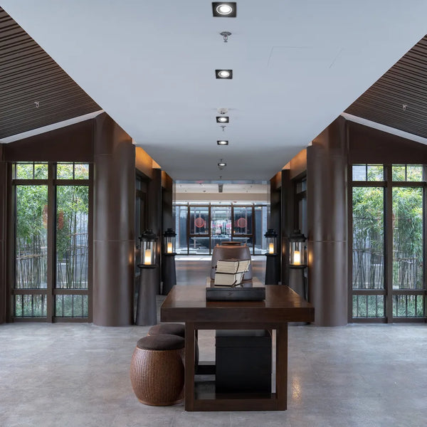 Foco empotrable cuadrado GU10 iluminando una sala de estar moderna con decoración elegante y estética contemporánea.143-03400