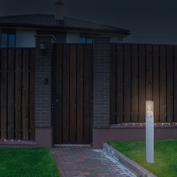 Luz bollard blanca para exteriores, ideal para caminos y jardines en decoración moderna, proporcionando iluminación funcional y elegante.