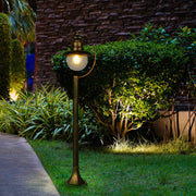 Luz de camino exterior tipo bolardo, ideal para jardines con estilo contemporáneo, con un diseño negro y detalles dorados.