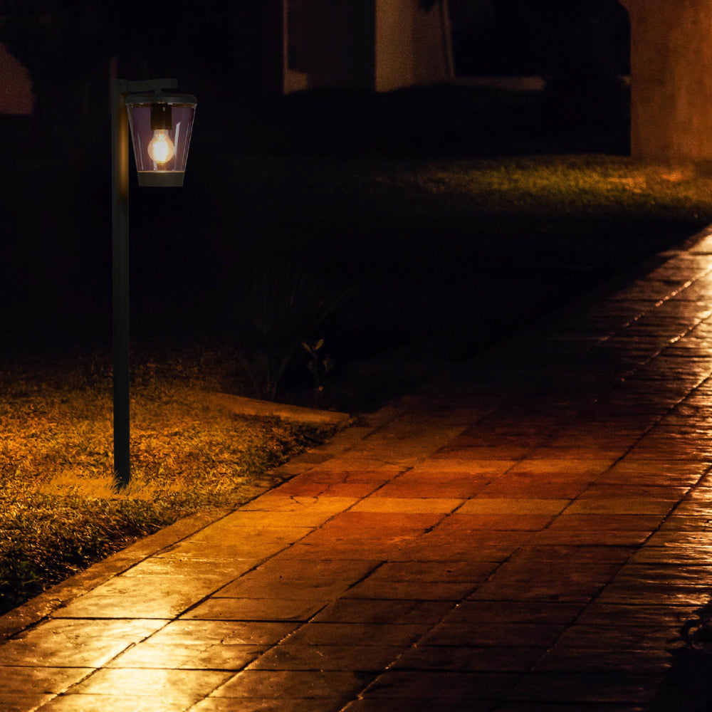 Luz de bolardo para exteriores, ideal para jardines y caminos, con diseño moderno en gris oscuro que realza cualquier paisaje.