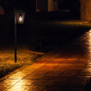 Luz de bolardo para exteriores, ideal para jardines y caminos, con diseño moderno en gris oscuro que realza cualquier paisaje.