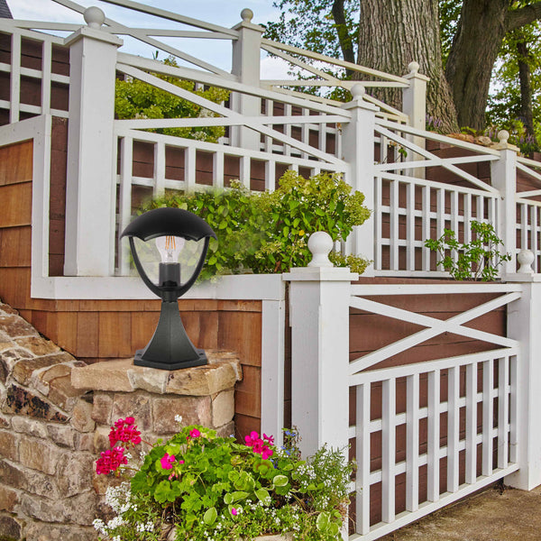 Lámpara de pedestal exterior en forma de farol negro, ideal para patios y jardines con estilo contemporáneo.