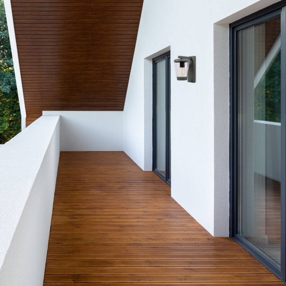 Luz de pared moderna en forma de farol, ideal para exteriores, complementa decoraciones contemporáneas en patios o entradas.