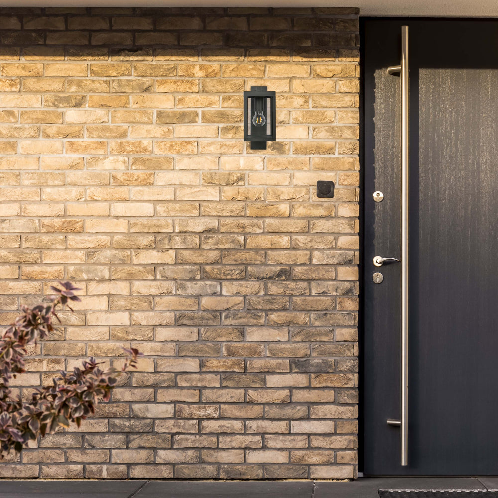 Lámpara de pared exterior en gris oscuro, perfecta para patios o entradas con estilo rústico y elegante.