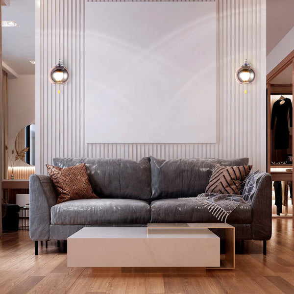 Lámpara de pared de metal con esfera de vidrio ámbar, ideal para ambientes contemporáneos como salones o pasillos.