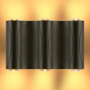 Aplique de pared LED moderno en forma de lumbrera corrugada, ideal para exteriores en decoraciones contemporáneas.
