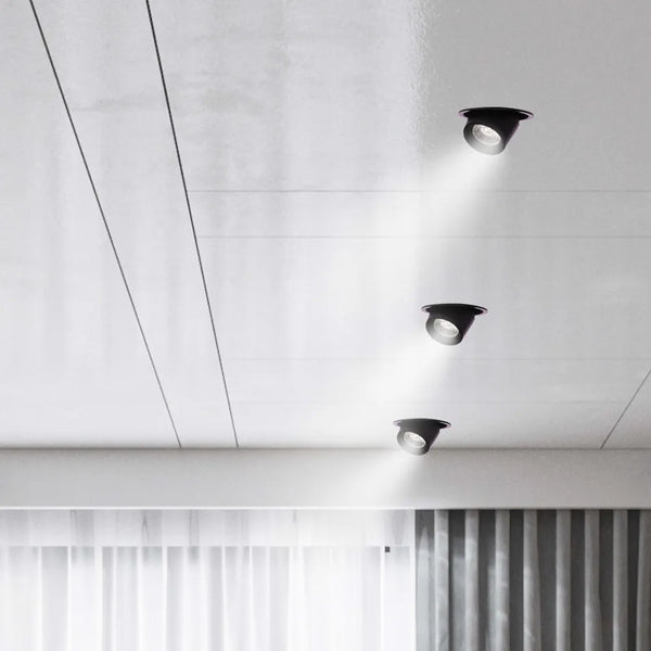 Iluminación LED moderna de empotrado iluminando una sala de estar con decoración minimalista, destacando la característica de cardán ajustable para una iluminación versátil.143-03410