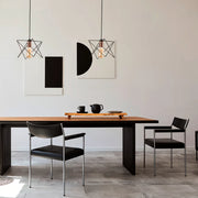 Luminaria colgante de jaula de metal en color oro rosa y negro complementa perfectamente un comedor moderno con decoración industrial.159-17026
